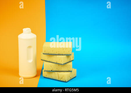 means for washing dishes and sponges on a colored background. household chores Stock Photo