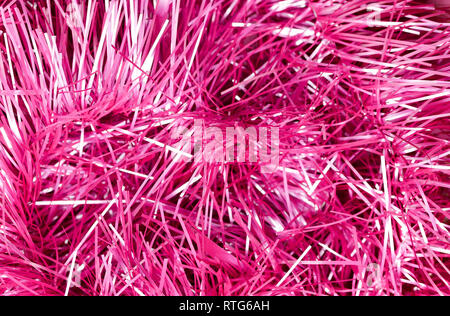 An abstract textured background of close up pink and silver Christmas tinsel Stock Photo