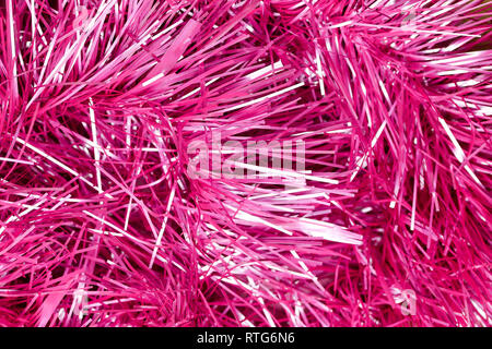 An abstract textured background of close up pink and silver Christmas tinsel Stock Photo