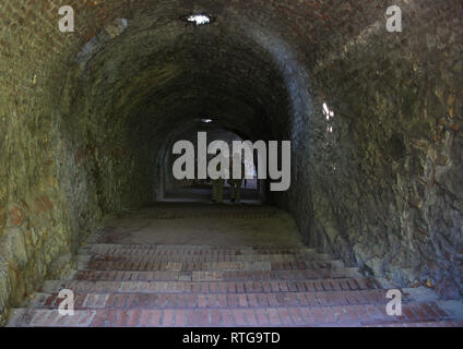 Elderly couple walking through a dark tunnel Stock Photo