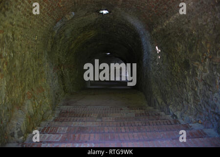 Long dark tunnel with stairs going down Stock Photo