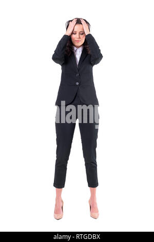 Stressed overworked young business woman having headache with head in hands. Full body isolated on white background. Stock Photo