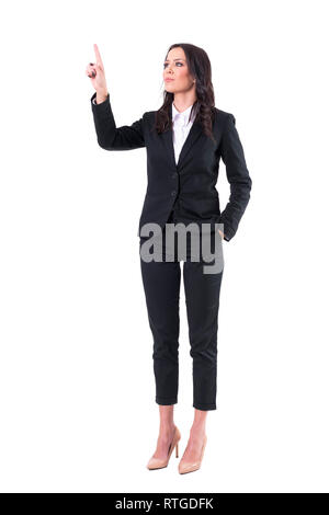 Confident elegant business woman pointing finger touching virtual reality push button screen. Full body isolated on white background. Stock Photo