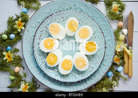 Easter table setting with flowers and eggs. Decorative plates with boiled eggs Stock Photo