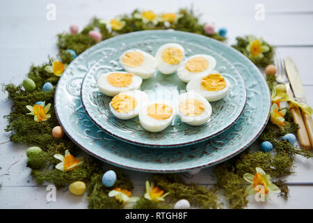 Easter table setting with flowers and eggs. Decorative plates with boiled eggs Stock Photo