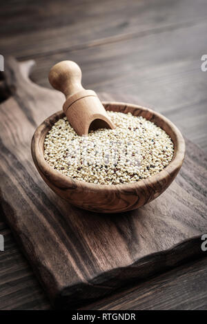 White Raw quinoa seeds in the wooden bowl on wooden background closeup Stock Photo