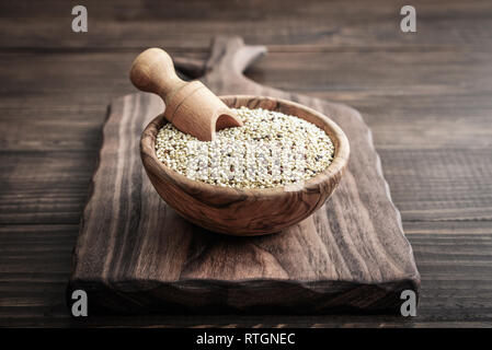 White Raw quinoa seeds in the wooden bowl on wooden background closeup Stock Photo