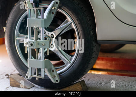 Car on stand with sensors on wheels for wheels alignment camber check in workshop of Service station. Stock Photo