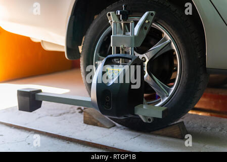 Car on stand with sensors on wheels for wheels alignment camber check in workshop of Service station. Stock Photo