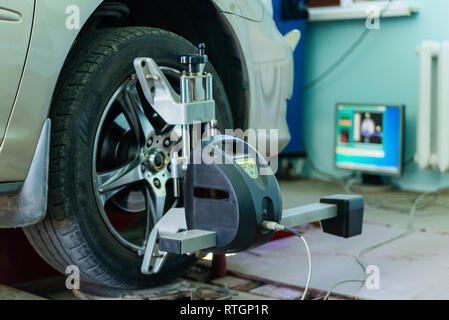 Car on stand with sensors on wheels for wheels alignment camber check in workshop of Service station. Stock Photo