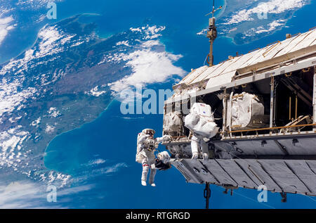 Astronauts on a space walk and the International Space Station with a view of Earth Stock Photo