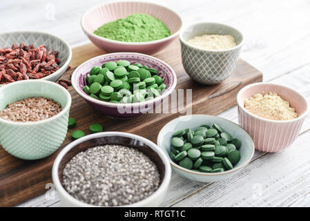 Different super foods in bowls on white wooden background closeup Stock Photo