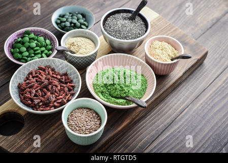 Different super foods in bowls on a wooden background Stock Photo