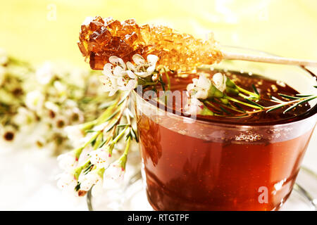 Beautifully decorated flower honey in a glass. On top there is a candy sugar stick. Stock Photo