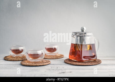 Tea in small glass cups with teapot on light background Stock Photo