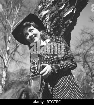 Amateur photographer in the 1940s. A young woman is photographing on a spring day. The camera is a Rolleiflex by the german company Rollei for 60 mm film. She is the actress Barbro Kollberg, 1917-2014.    Sweden 1942. Photo Kristoffersson Ref A1-4 Stock Photo