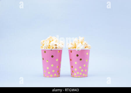 cup of tasty popcorn on a blue background Copy space Stock Photo