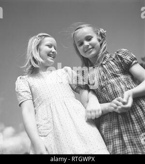 Summer in the 1940s. Two girls in summer dresses are enjoying the summer day. Photo Kristoffersson. Ref U53-6. Sweden 1946 Stock Photo