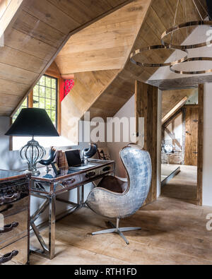Chrome desk and Aviation armchair by Andrew Martin with doors made of reclaimed Scandinavian pine scaffold boards Stock Photo