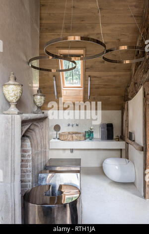 Circular stainless steel LED lights designed by Mirka McNeill with 15th century French fireplace Stock Photo