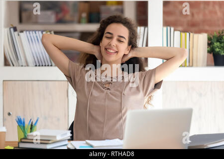 Happy girl student taking break from study relaxing in library Stock Photo