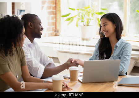 African businessman handshaking asian businesswoman thanking for good work Stock Photo
