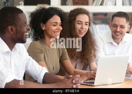 Happy multi ethnic research team working together using laptop Stock Photo