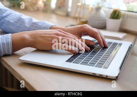 Working at home with laptop woman writing a blog. Female hands on the keyboard. Close up Stock Photo