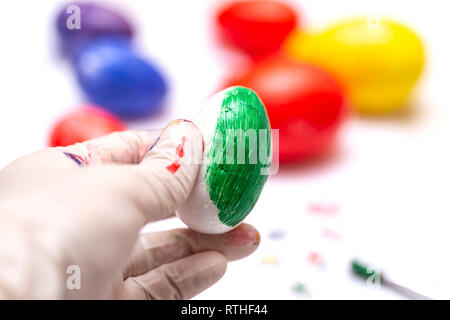 Person paint a egg made of polystyrene. Colorized acrylic egg Stock Photo