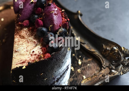Homemade cake decorated with fruit, chocolate souffle pudding cake filled with fresh berries on the Golden tray Stock Photo