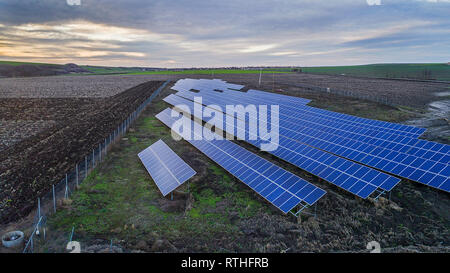 Solar panel produces green, environmentaly friendly energy from the setting sun. Aerial view from drone. Landscape picture of a solar plant Stock Photo