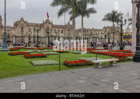 Lima Peru, June 2018: The gardens with bright colors of the Plaza de Armas in the city of Lima, contrast with a typical gray day in the city. Stock Photo