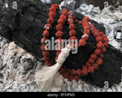 Rosary prayer beads on the ash cinder background. Rudraksha. Mala. Mantra. 108 beads.
