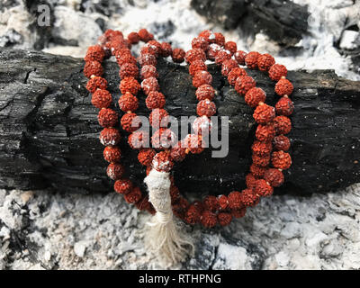 Rosary prayer beads on the ash cinder background. Rudraksha. Mala. Mantra. 108 beads.