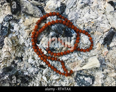 Rosary prayer beads on the ash cinder background. Rudraksha. Mala. Mantra. 108 beads.
