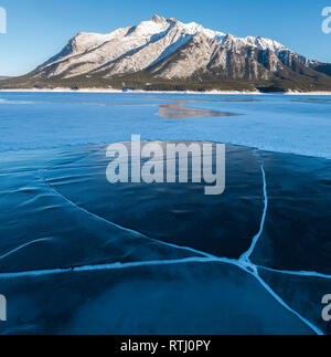 Cracks and methane bubbles trapped in ice covering Abraham Lake with Mount Michener in the background, Alberta, Canadian Rockies, Canada Stock Photo