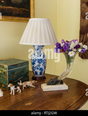 Cut flowers in glass vase with lamp and ornaments Stock Photo
