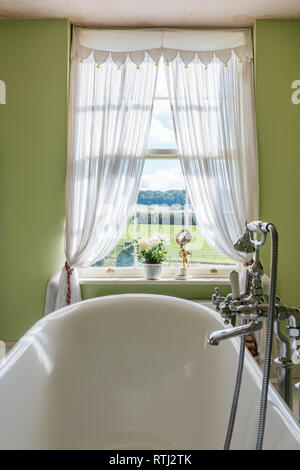 Bathroom walls painted in Green Verditer by Little Greene with view to Dorset countryside Stock Photo