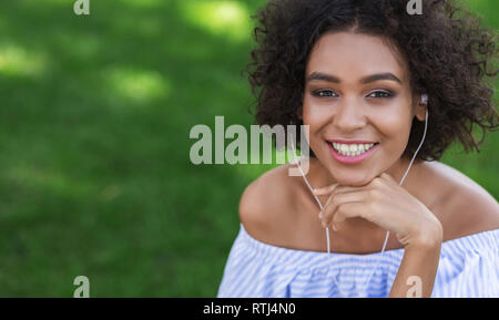 Excited black woman listening to music outdoors Stock Photo