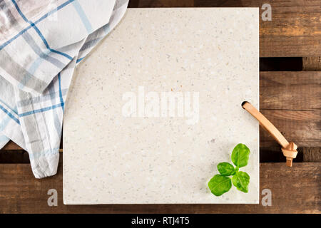 Concrete stone server with space for text on rustic wood plank surface. Arranged cloth and basil. Top view, flat lay, from above, overhead. Stock Photo