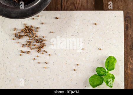 Concrete stone server with space for text on a rustic wood plank surface. Arranged mortar, basil and coriander. Top view, flat lay, from above. Stock Photo