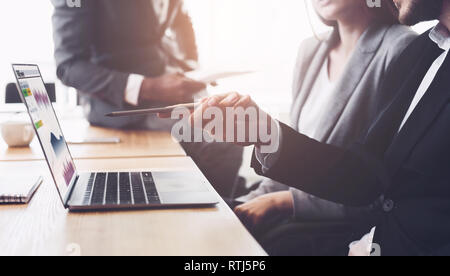 Coworkers discussing creative project on laptop at meeting Stock Photo