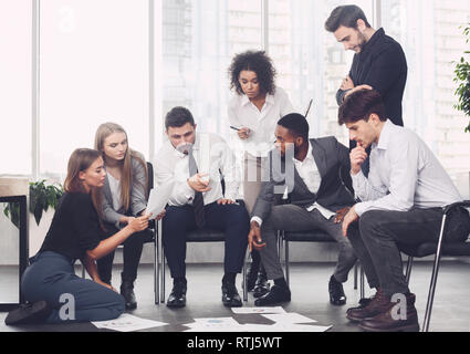 Planning strategy together. Business team looking at papers Stock Photo
