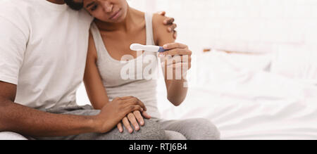 Black couple with a negative pregnancy test result Stock Photo