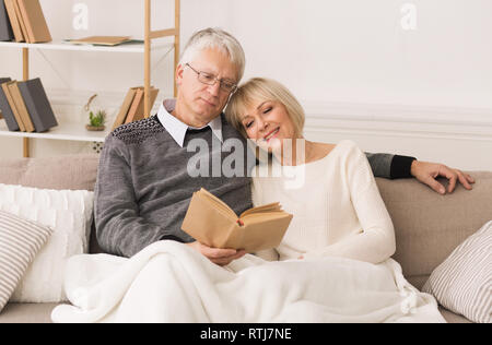 Happy senior couple reading book, spending time together Stock Photo