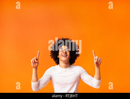 Stylish black man in glasses pointing away at empty space Stock Photo