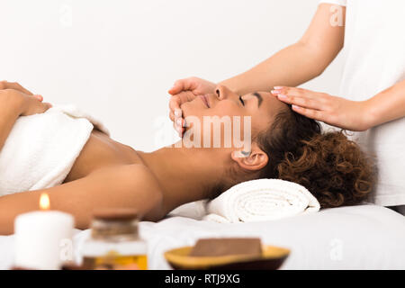 Woman enjoying face massage in spa salon Stock Photo