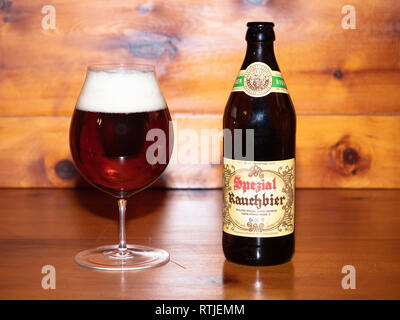 Bamberg, Germany - March 1 2019: Dark Bamberg Smoked Beer from the famous Spezial Brewery in Bamberg, Bavaria, Germany in the Glass with its Bottle on Stock Photo