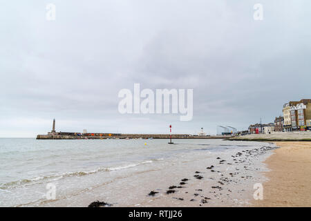 Margate resort on the kent coast during wintertime. View along beach with incoming tide, Turner Centre and the harbour in background. Overcast sky Stock Photo