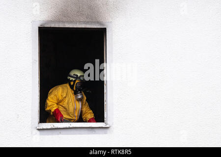 02 March 2019, Bavaria, Nürnberg: A fireman in protective clothing walks through a burnt-out house. Five people died in a fire in a detached house in Nuremberg. Photo: Lino Mirgeler/dpa Stock Photo